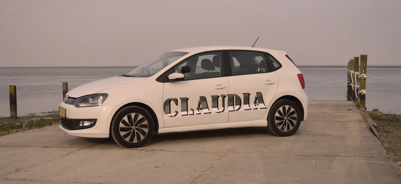 De witte lesauto van Autorijschool Claudia aan het water